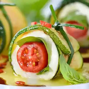 Mozzarella-Zucchini-Röllchen gefüllt mit Cocktailtomaten und Basilikum