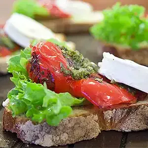 Ziegenkäse auf Toskana-Brot mit gegrillter Paprika an Rucola-Pesto