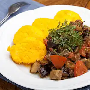 Teller mit Polenta und frischem, gebratenem Gemüse.
