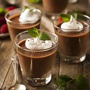 Teller mit Schokoladen-Mousse, Sahne und Minz-Garnitur.