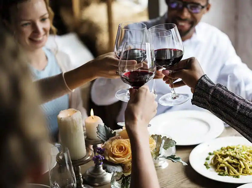 Freunde beim Essen mit Pasta und Rotwein.