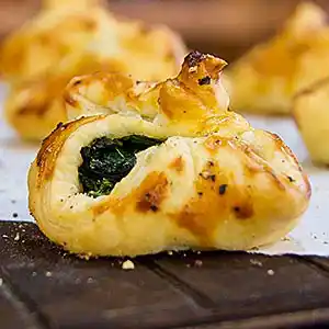 Gebackene Blätterteigtaschen mit Spinat-Ricotta-Füllung.