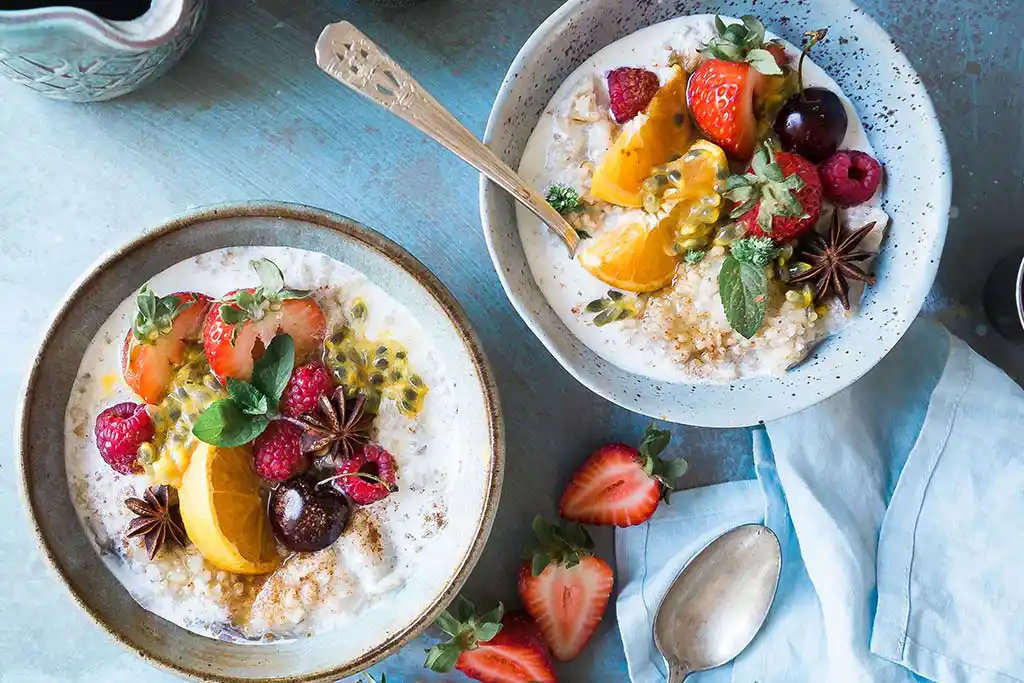 Tisch mit Milchreis mit Früchten und Yoghurt.