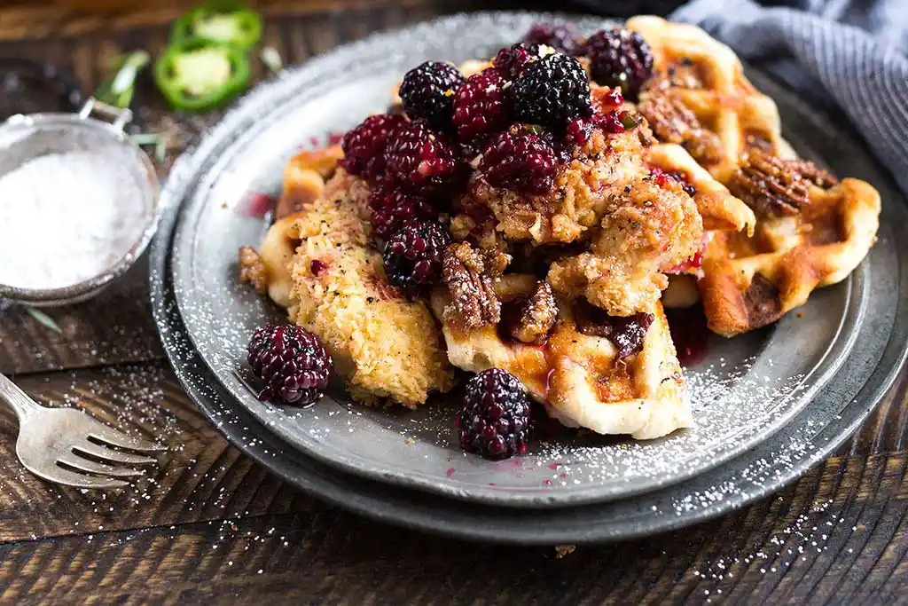 Tisch mit Pfannkuchen mit Brombeeren.