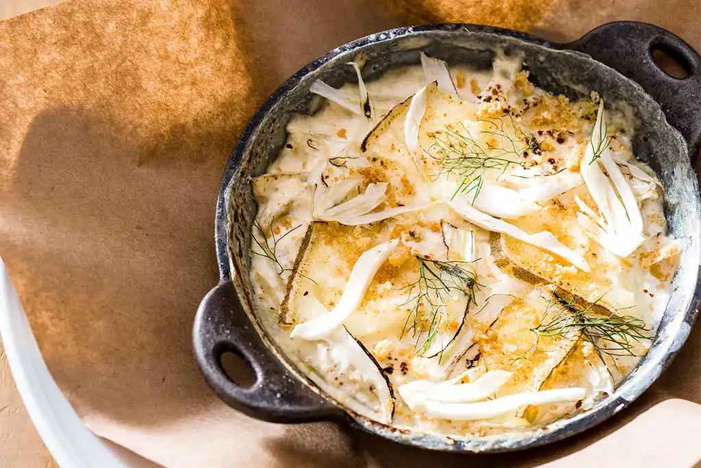 Im Schmortopf Fenchel-Gratin. Fenchel mit Käse überbacken an Bechamelsauce.