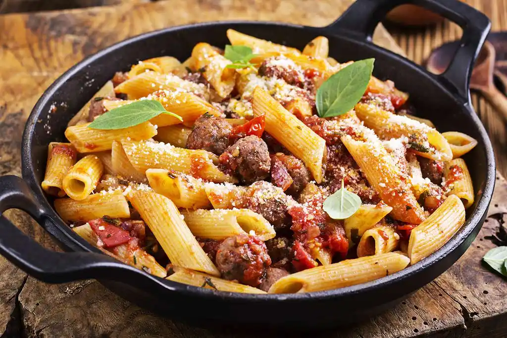 Teller mit Pasta mit Fleischbällchen und Tomatensauce.