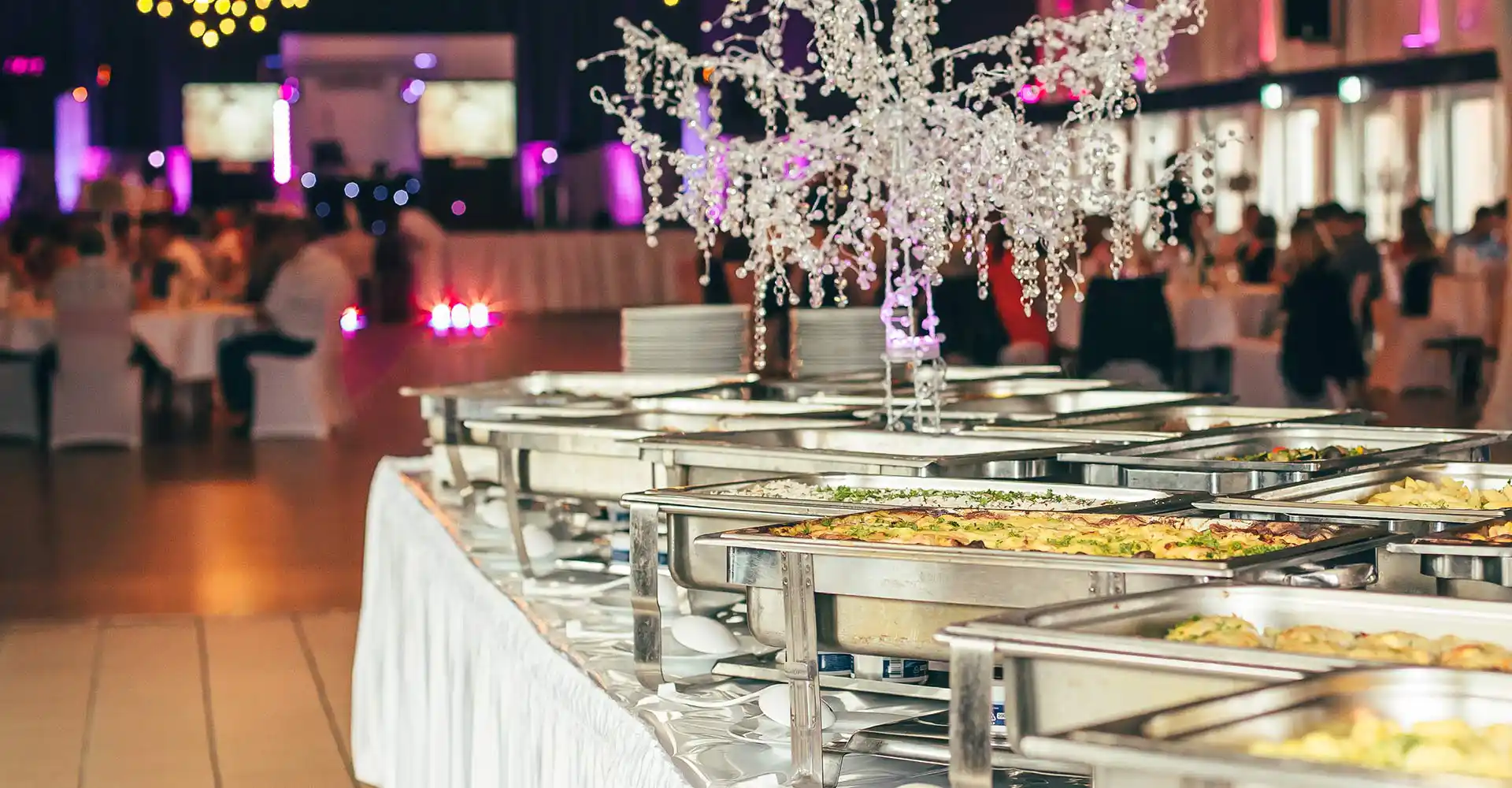 Saal mit Gästen und Buffet.