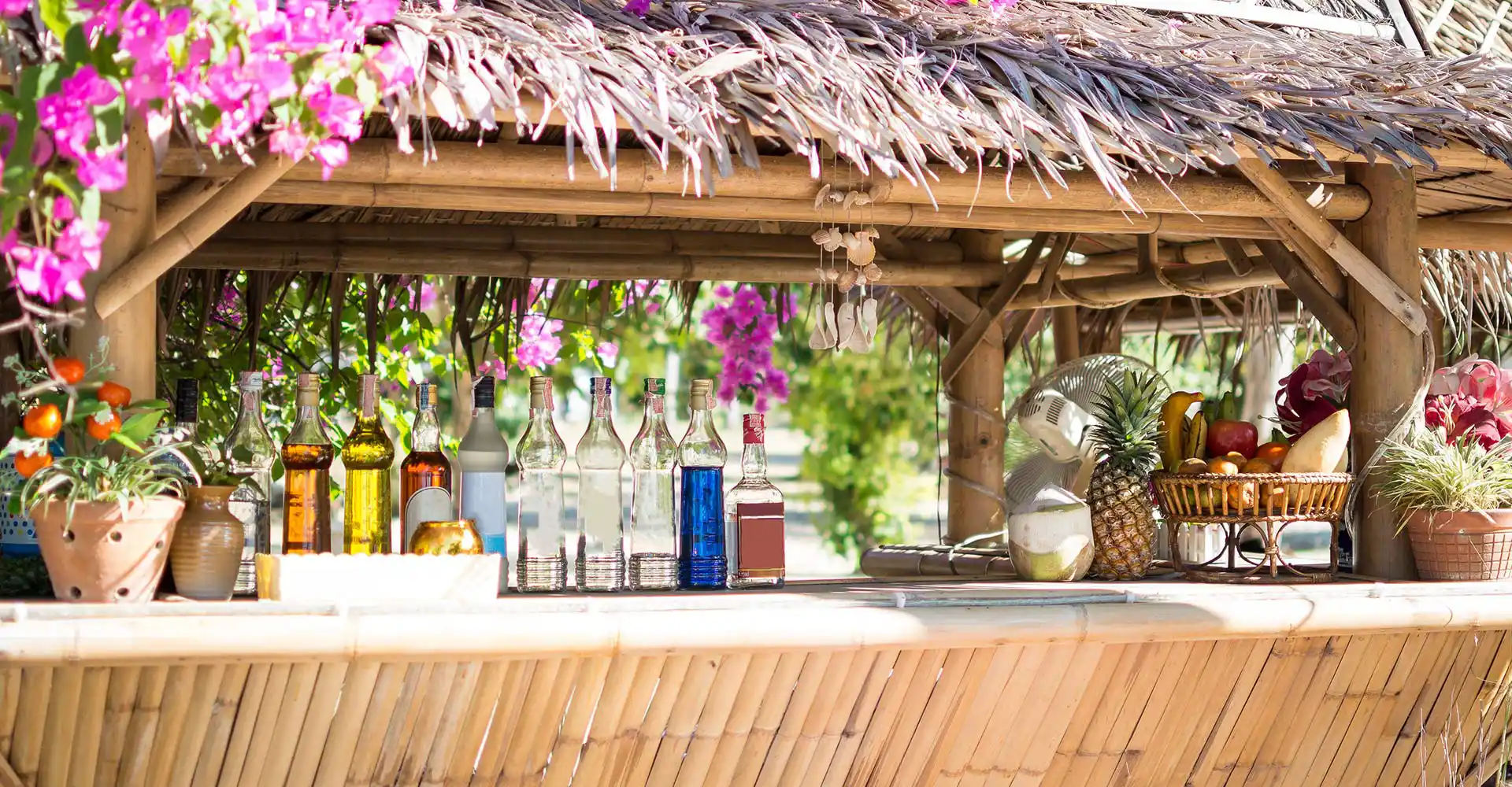 Sommerliche Outdoor-Bar mit Blumen und Getränken.