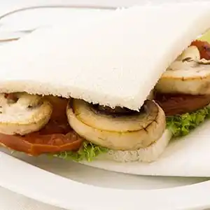 Tramezzini mit Salat, Tomaten, Zwiebeln und Pilzen.