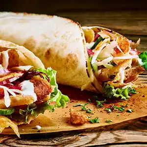 Wrap mit Lammfleisch, Salat, Zwiebeln und Tomate.