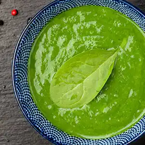 Teller mit Spinatsuppe und Knoblauch.