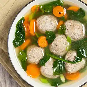 Teller mit Gemüsesuppe und Bratknödeln.
