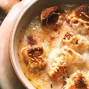 Teller mit Zwiebelsuppe und Käse überbacken.
