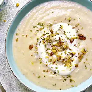 Teller mit Blumenkohlsuppe und Walnüssen.