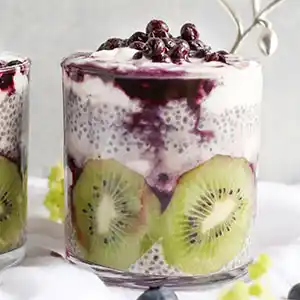 Joghurt-Sahne-Dessert mit Goji Beeren, Kiwi und Blaubeeren.