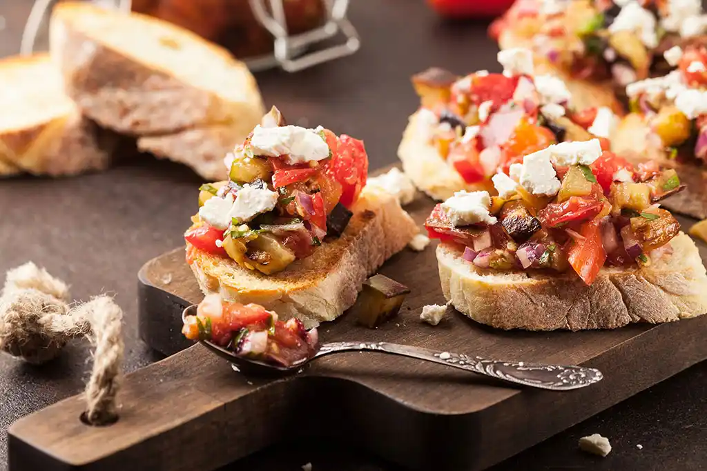 Bruschetta mit Tomaten, Oliven, Paprika und Mozzarella.