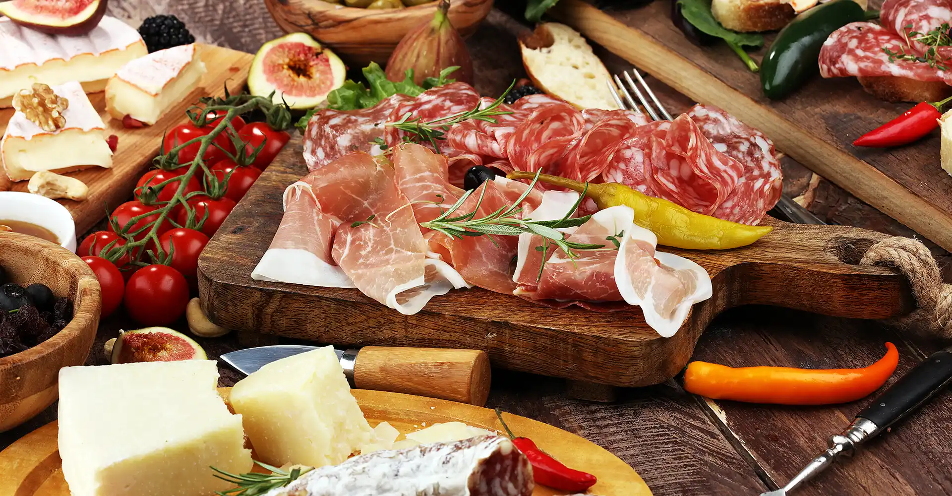 Antipasti-Brett mit Salami, Schinken, Käse, Tomaten und Peperoni.