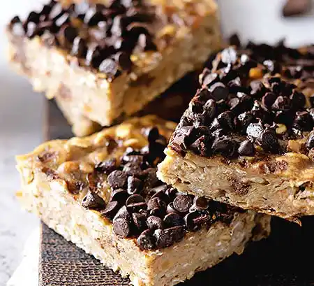 3 Hafer-Blondie mit Erdnussbutter und Schokochips auf Teller.