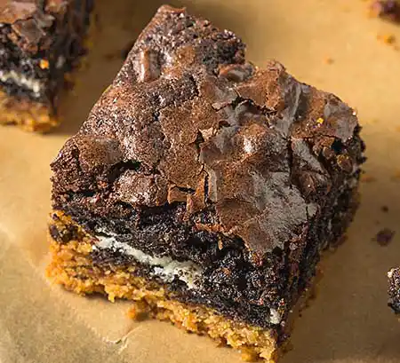 Brownie auf Teller mit Coockies und Kaffeecreme