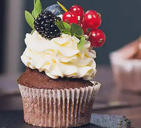 Cupcake mit Sahne Topping und frischen Früchten.