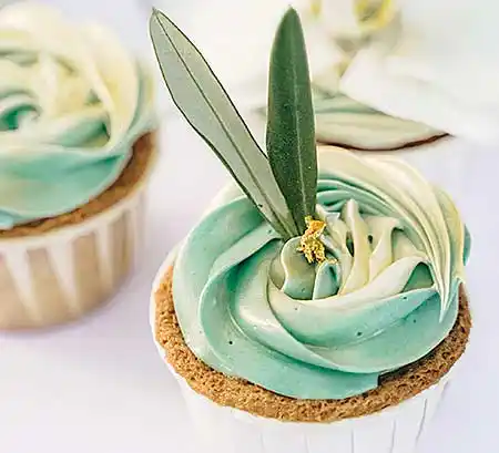 Cupcake mit blauer Buttercreme und Blumendekor.