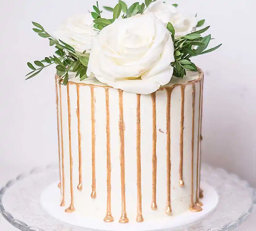 1-stöckige weiße Hochzeitstorte mit Karamell-Drip und Blumendekor.