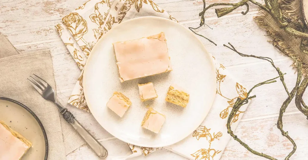 Festlich gedeckter Tisch mit Teller und Kuchenstücken darauf.