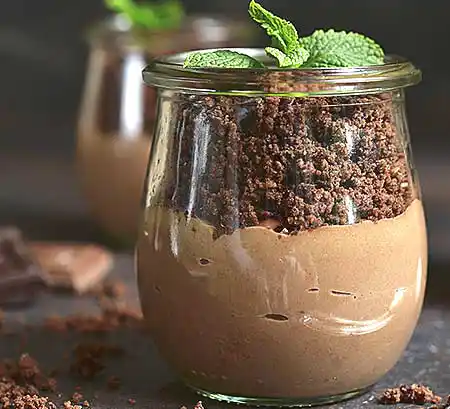 Gläser mit Haselnuss-Mousse mit Schoko-Cookies-Crunch und Minze.