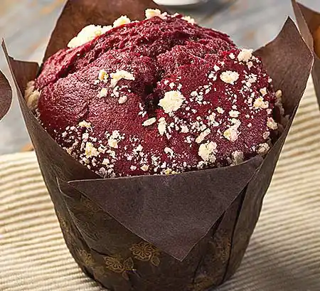 Dunkler Schoko-Muffin mit Rote-Beete in braunem Papier eingewickelt.