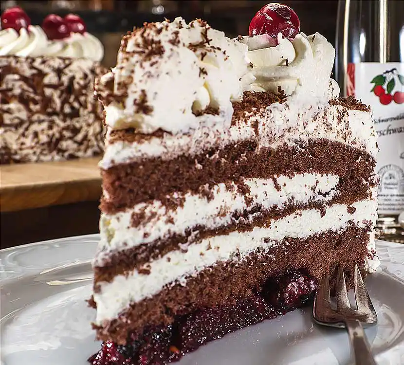 Teller mit Stück von leckerer Schwarwälder Kirschtorte.