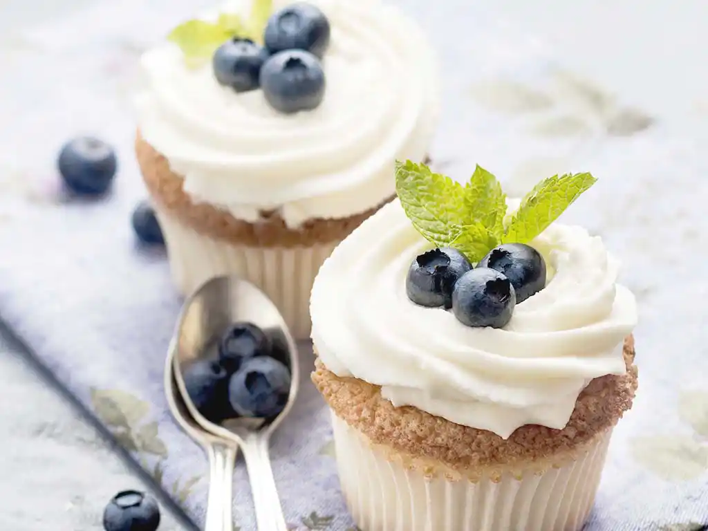 2 weiße Cupcakes mit Blaubeeren.