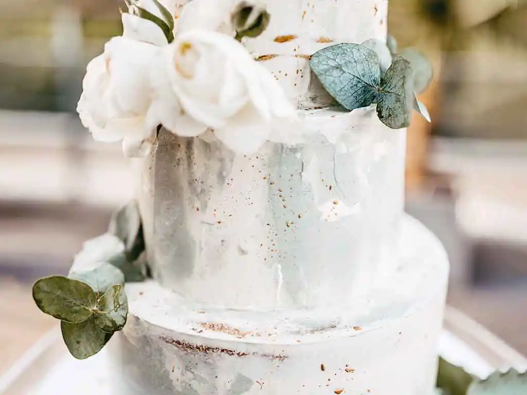 Hochzeitstorte im Ombré Design (schattiert) mit weißem Blumendekor.