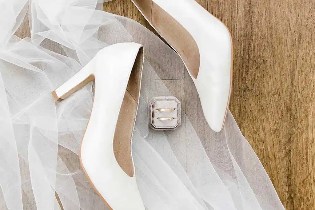 Stilleben mit Frauenhochzeitsschuhen und Eheringen